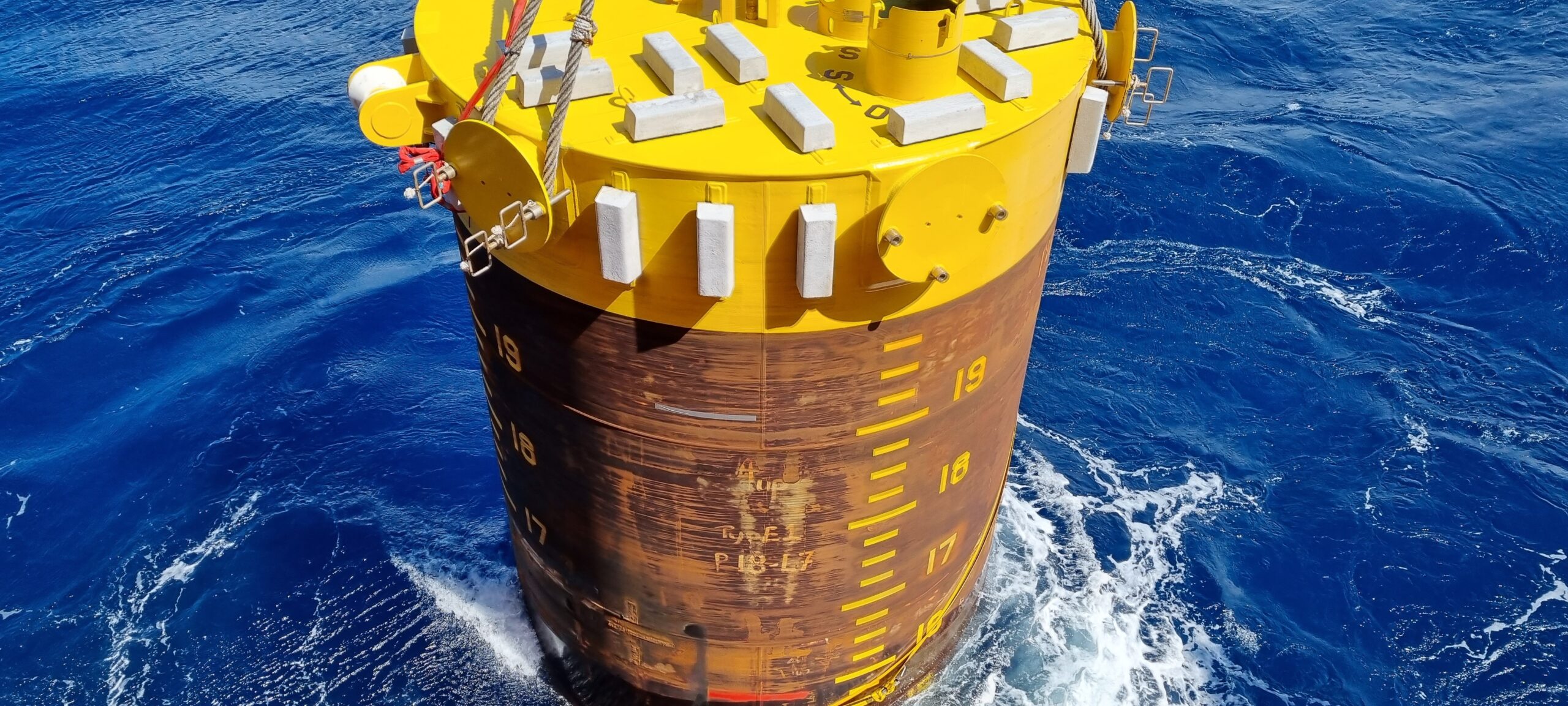 a crane lifts a pile during offshore construction operation